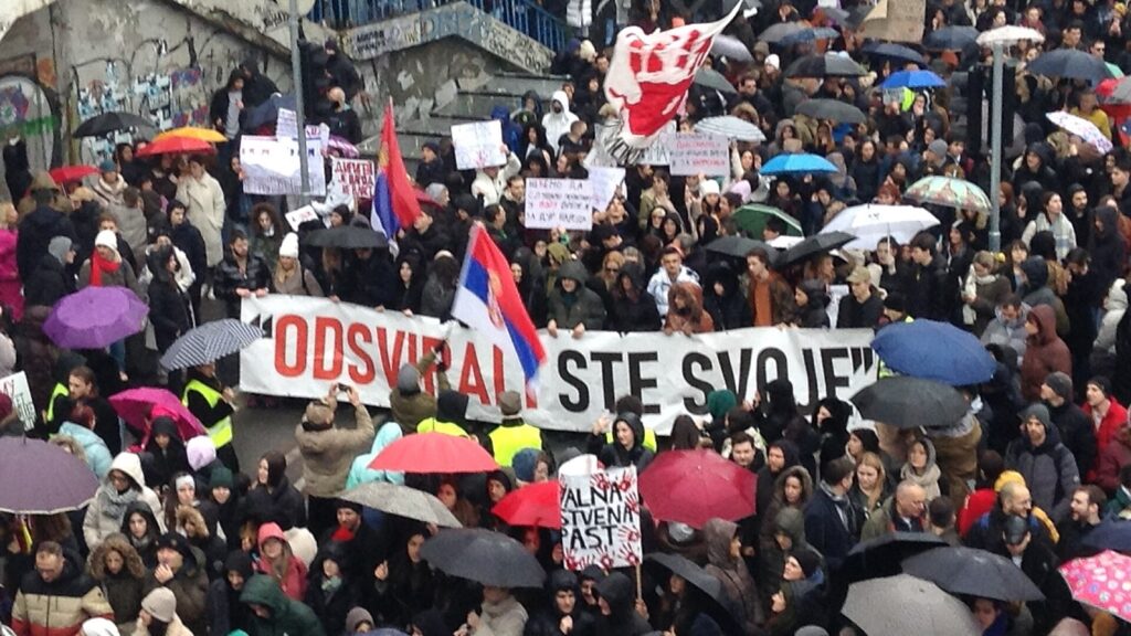 Hiljade ljudi na protestu u Beogradu, sa transparentom „Odsvirali ste“, zastavama Srbije i kišobranima.